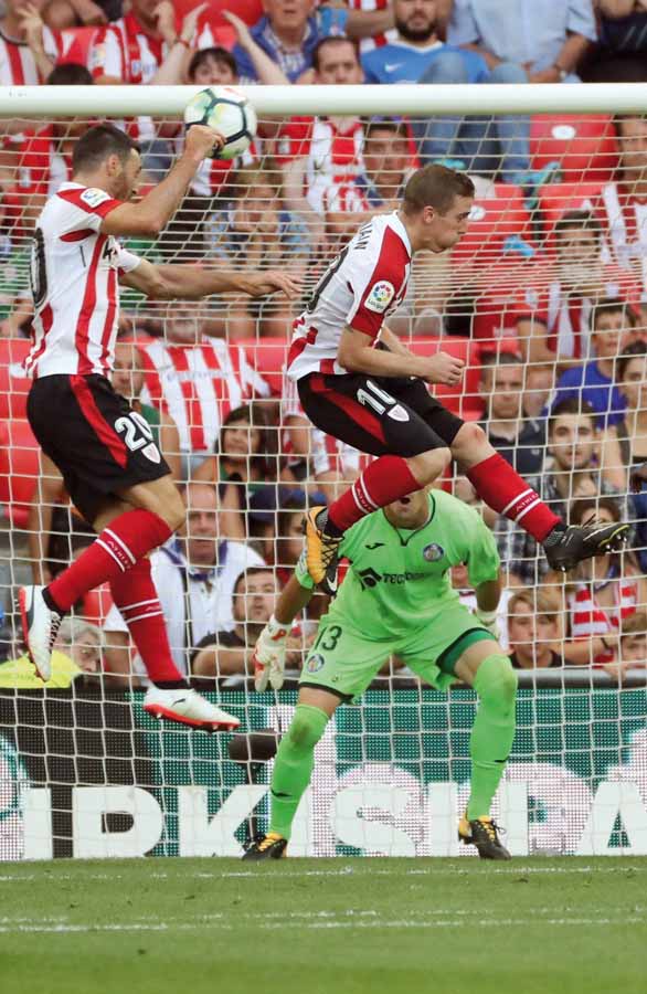 GRA338. BILBAO, 21/01/2016.- Los jugadores del Athletic de Bilbao Aritz Aduriz (i) e Iker Muniain (d) intentan cabecear el balón aéreo ante el portero del Getafe F.C. Vicente Guaita (fondo), durante el partido correspondiente a la primera jornada de LaLiga Santander que se disputa esta tarde en el estadio de San Mamés. EFE/Luis Tejido