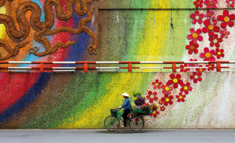 Una vendedora de flores con su bicicleta en la calle de cerámica del casco antiguo de Hanoi. ©Zay Yar Lin