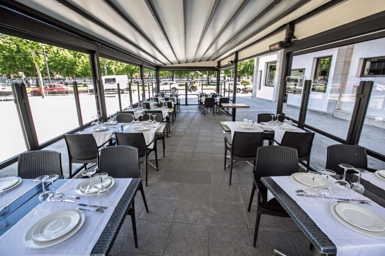 Terraza del restaurante Larruzz en Bilbao con mesas y sillas