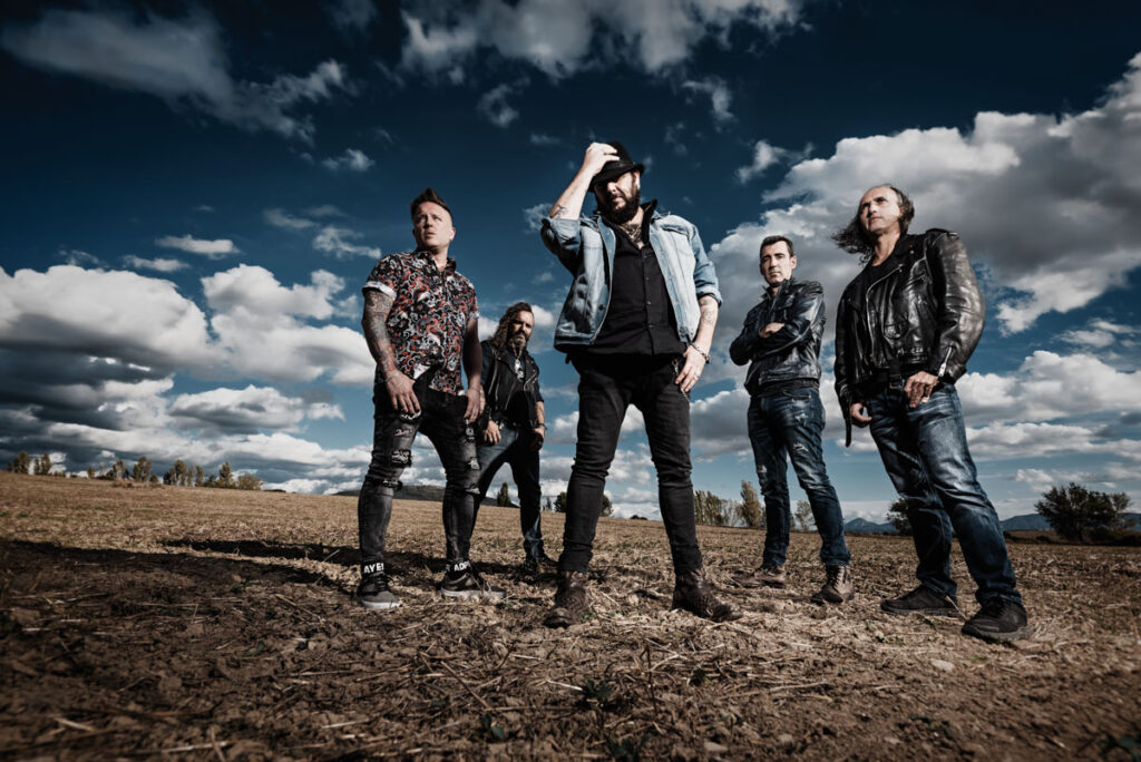 Fotografía de la banda Marea en un paisaje abierto con nubes.
