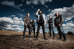 Fotografía de la banda Marea en un paisaje abierto con nubes.