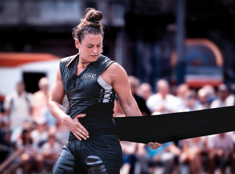 Concentración y ritual antes del levantamiento: ajustar la faja y preparar el cuerpo para la piedra.