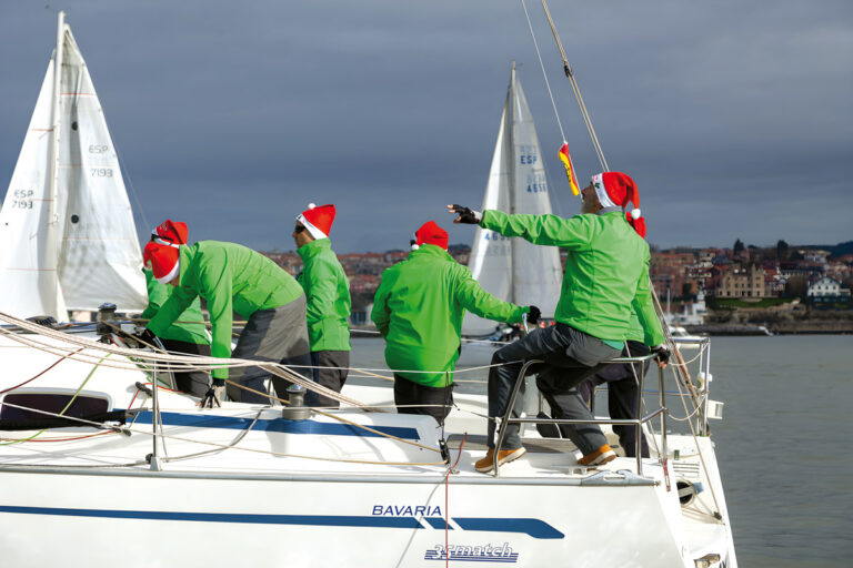Regatistas en un barco de la Regata del Gallo con gorros navideños. © Rafa Aspiunza (R.C.M.A. - R.S.C.)
