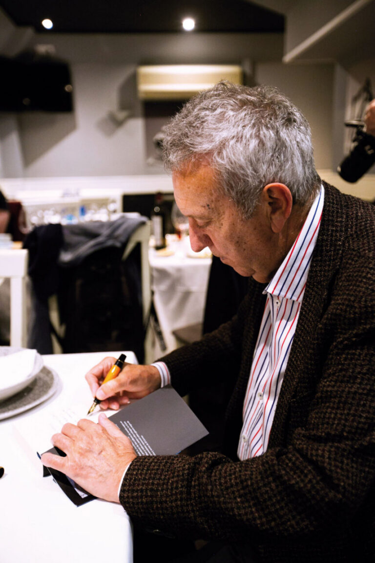 Juan Infante firmando un libro en un ambiente acogedor