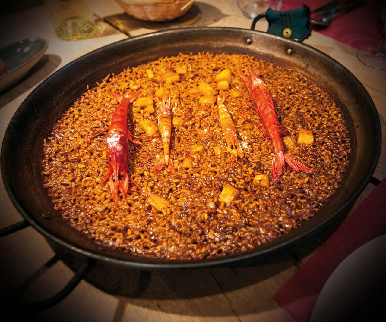 Plato de arroz con mariscos y gambas en una paellera
