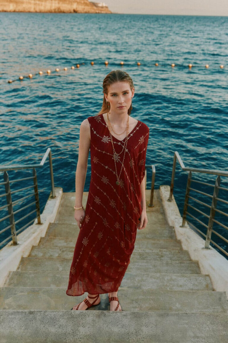 Modelo luciendo un vestido boho rojo junto al mar © Hoss Intropia
