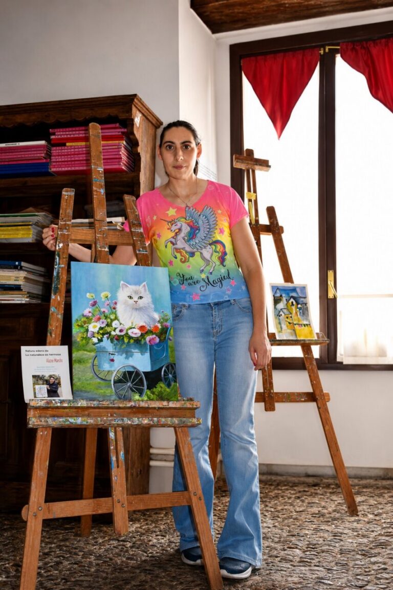 Alazne Mantxa en su taller con pinturas de un gato y flores