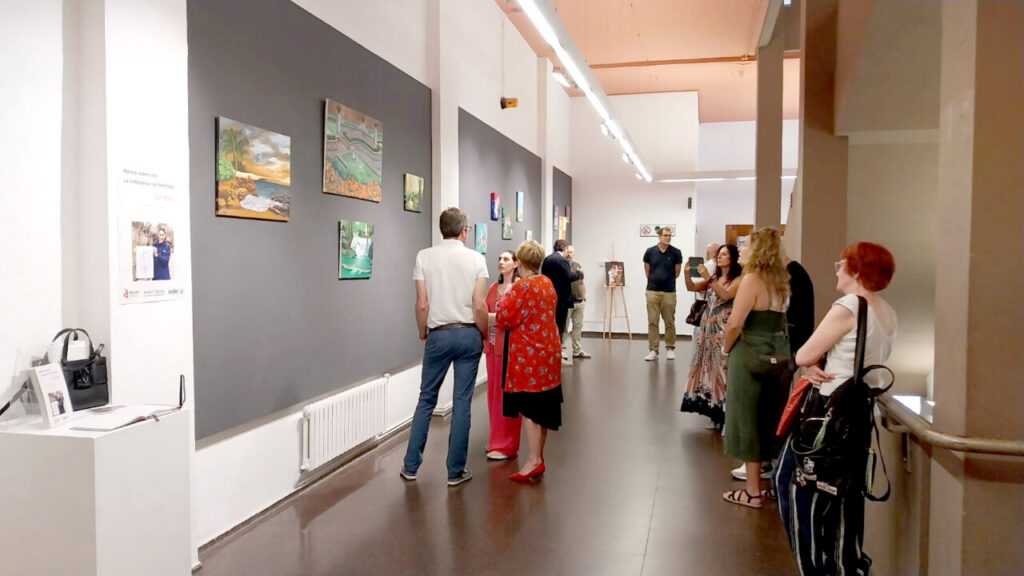 Visitantes observando obras en la exposición de Alazne Mantxa